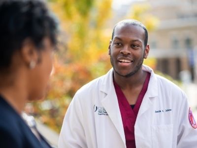 A smiling man in a white coat with a Health Equity Leadership Institute logo.